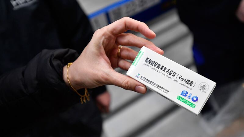 2021年2月16日,匈牙利布达佩斯的一家药品批发商,一名妇女手拿中国国药集团新冠疫苗药盒。 (美联社)