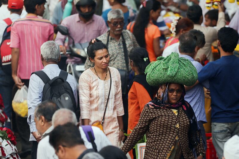 People walk through a crowded market in Mumbai, India, Dec. 22, 2022.