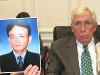 Dân biểu Frank Wolf và ảnh của nạn nhân anh Nguyễn Thành Năm, tại buổi điều trần của Ủy ban Nhân quyền Tom Lantos ở Quốc hội Hoa Kỳ, ngày 18 tháng 8. RFA PHOTO.